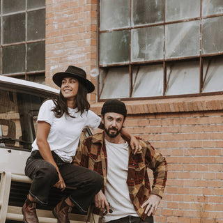 Laidback moment with couple wearing Will & Bear Black Wide Brim Hats by a vintage car