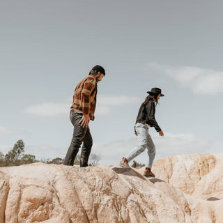 Adventure-ready couple wearing Will & Bear Black Wide Brim Hats on rugged rocky trail