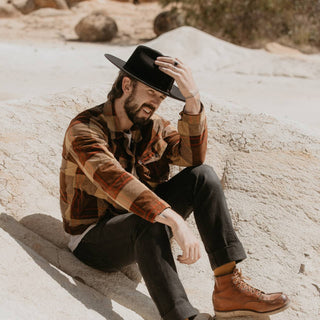 Man wearing Will & Bear Black Wide Brim Hat, enjoying rugged outdoor landscape