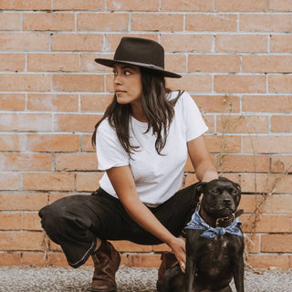 Relaxed urban scene featuring woman wearing Will & Bear Black Wide Brim Hat with her dog