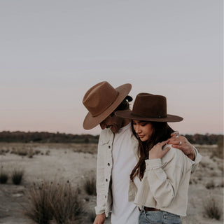 Couple wearing Will & Bear Brown Wide Brim Fedoras walking through rugged outdoor landscape