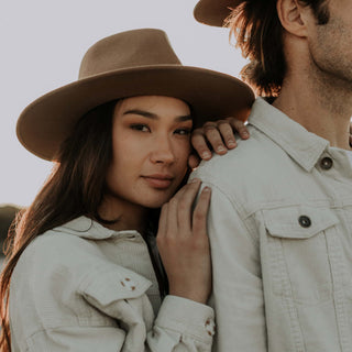 Close-up of couple featuring woman wearing Will & Bear Brown Wide Brim Fedora, cozy outdoor scene