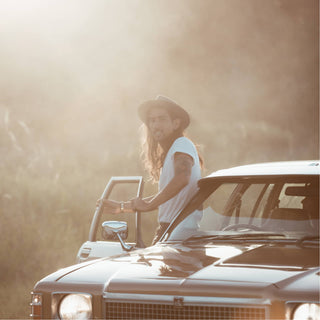Man wearing the Will & Bear Calloway Ash wide brim felt fedora beside a classic car during golden hour.