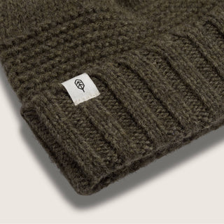 Close-up of Will & Bear Forest Green Beanie – Tasman Moss – ribbed detail and branded label on eco-conscious knitwear.