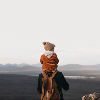 Child Wearing Will & Bear Little Tasman Fawn Kids Wool Cream Beanie – Outdoor Adventure in the Hills.