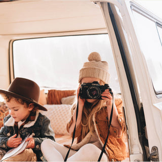 Kids Wearing Will & Bear Little Tasman Fawn Wool Cream Beanie sitting in back of Van – Cozy Travel Moments in Natural Wool.